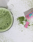 Happy Matcha Stick next to matcha in mug and matcha powder