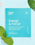 Energy & Focus Gum on blue background surrounded by gum tablets and mint leaves.