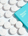 Energy & Focus Gum on blue background surrounded by gum tablets.