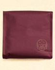 burgundy coffee bag with yellow skull illustrated on the bottom right hand corner. Inside the skull is "ONYX"