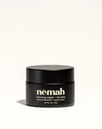 Renewing Nipple + Lip Balm in black canister on white background.