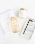 Geometry Linen Plaid Tea Towel, Mielle Marble Tray, Vivie Gold Candle Snuffer, Beverly + 3rd Home Sweet Home Candle, and Compagnie de Provence 16.7 oz Liquid Hand Soap laid out on white background.