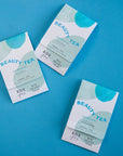 Three Pink Hibiscus Tea Sachets on blue background.