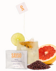 SAYSO Skinny Cardamom Paloma sachet with a Paloma cocktail in the background and a grapefruit to the right.