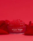 Red Roses Lip Scrub pot surrounded by rose petals on red background