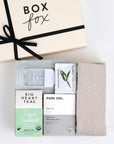 BOXFOX Creme Gift Box filled with Royal Treatmint Big Heart Tea, Pure Sol Charcoal Eye Pads, BOXFOX tan cozy socks, set of Herban Essentials Eucalyptus wipes and Touchland hand sanitizer