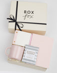 BOXFOX Original Creme Hustle Gift Box packed with Wit & Delight Pink Note to Self Journal, BOXFOX Pink Ceramic Mug, Well-Kept Hampton Tech Wipes, Sugarpaper Pink To Do Pad, and BOXFOX Pink Bullet Pen.