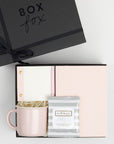 BOXFOX black Hustle Gift Box packed with Wit & Delight Pink Note to Self Journal, BOXFOX Pink Ceramic Mug, Well-Kept Hampton Tech Wipes, Sugarpaper Pink To Do Pad, and BOXFOX Pink Bullet Pen.