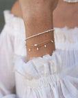 Poppy Pearl Bracelet on wrist with other bracelets