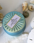 Casa Pacifica Petite Tin Candle surrounded by shells.