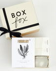 BOXFOX Creme Gift Box filled with Voluspa Coconut Papaya Tin Candle, Formulary 55 Eucalyptus + Peppermint Foot Soak and Mast Brothers 2 Mini Tea Chocolate Bars