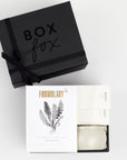 BOXFOX Black Gift Box filled with Voluspa Coconut Papaya Tin Candle, Formulary 55 Eucalyptus + Peppermint Foot Soak and Mast Brothers 2 Mini Tea Chocolate Bars