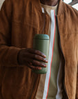 Man holding green Carter Move Mug.