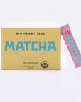 Yellow Happy Matcha Sticks box contains 10 servings. Next to box is the pink single serving matcha powder stick
