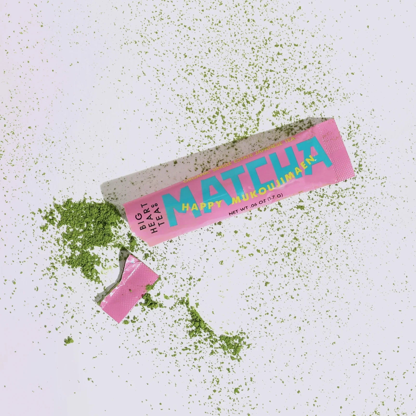 Happy Matcha Stick ripped open and surrounded by matcha powder