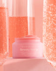 Pink Champagne Beauty Sleep Overnight Lip Mask pot surrounded by sparkling pink champagne in flutes