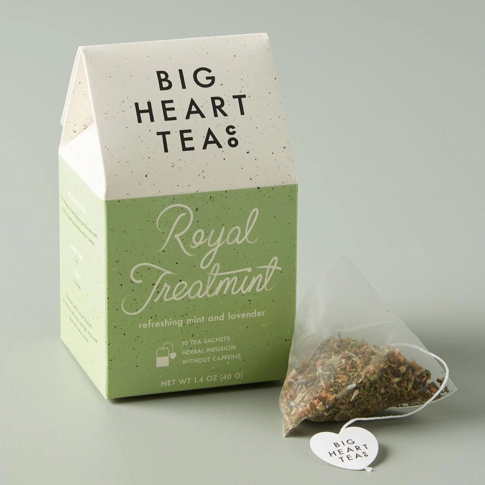 House-shaped tea box in green with a tea sachet outside and to the right of the box.