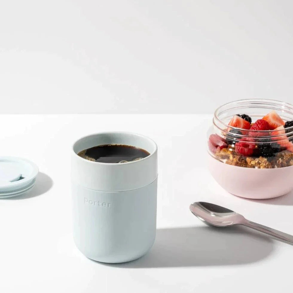 Mint Ceramic Porter Mug filled with coffee, next to bowl of granola and berries and spoon.