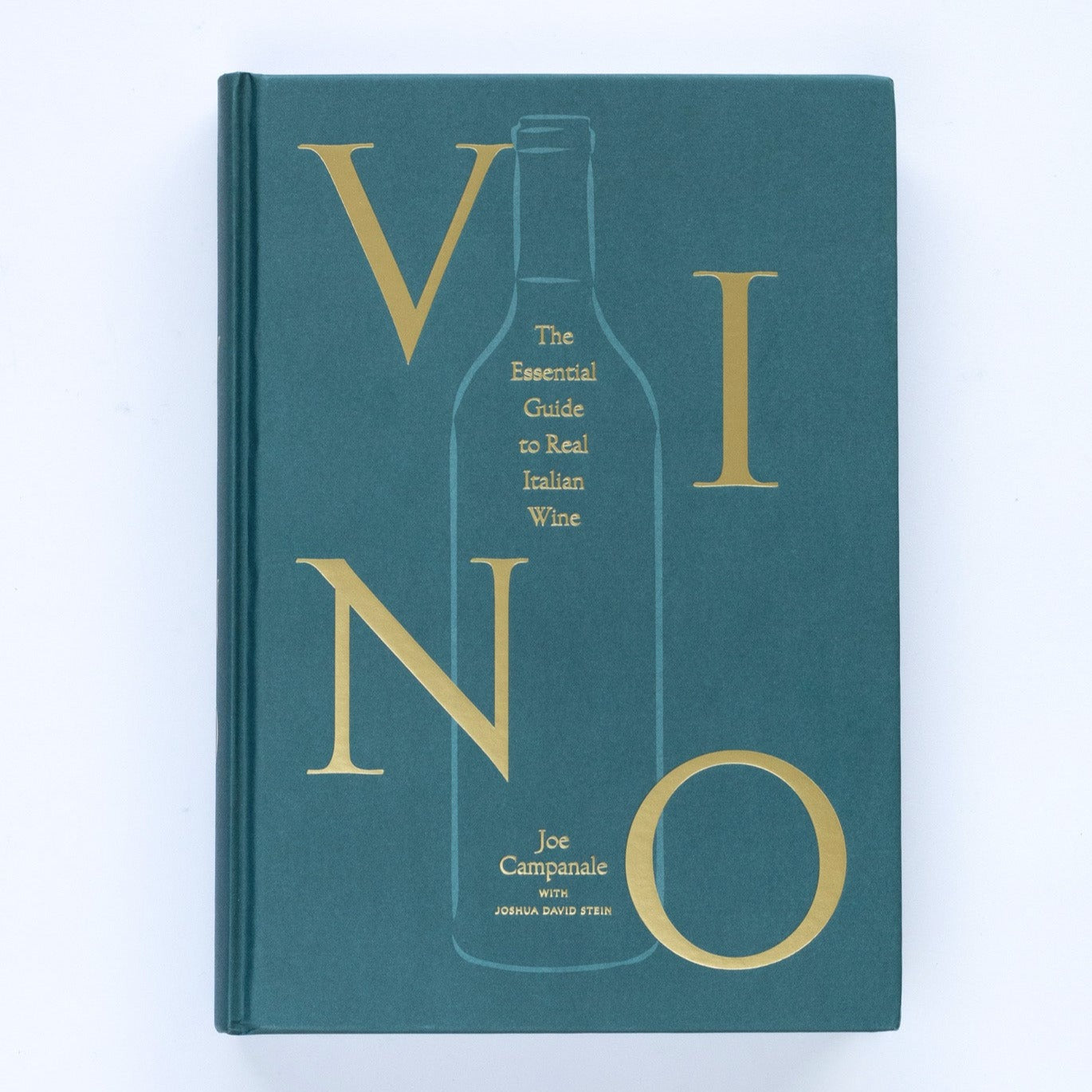 A blue green hardcover, linen wrapped book with light green illustration of wine bottle in middle and gold embossed text that reads, &quot;Vino: The Essential Guide to Real Italian Wine&quot; photographed on white background.