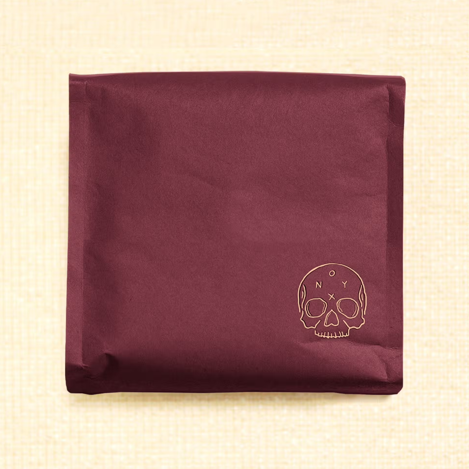 burgundy coffee bag with yellow skull illustrated on the bottom right hand corner. Inside the skull is "ONYX"