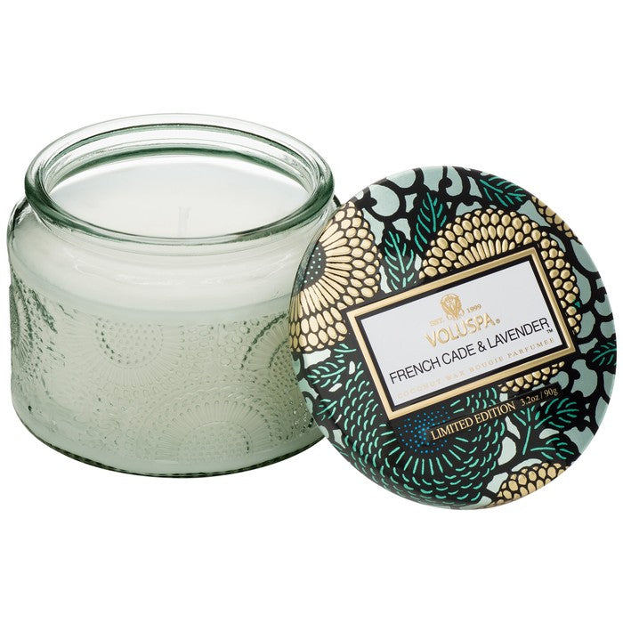 Candle in light green jar with teal and gold floral lid.