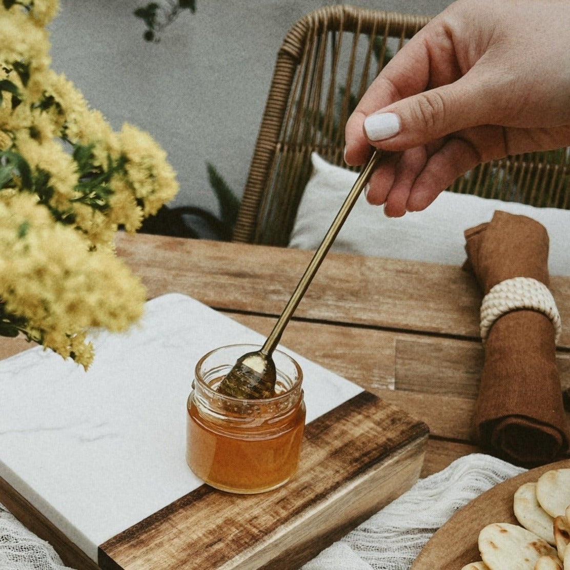 Honey dipper in honey pot on tablescape.
