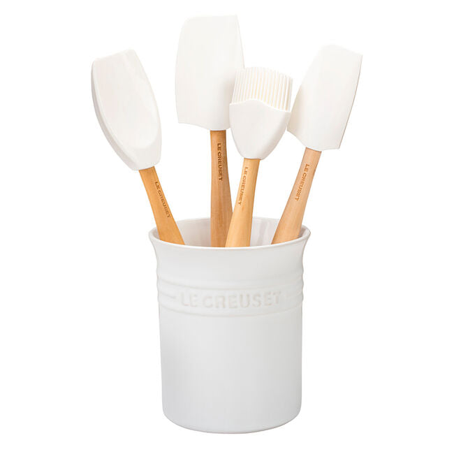 White utensil holder with four cooking utensils inside.