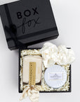 BOXFOX Matte Black Gift Box with Pinch Provisions Ivory Velvet Bridal Emergency Kit, Voluspa White Tin Candle and 2 Ivory Silk ScrunchiesBOXFOX For the Bride Gift Box filled with Ivory crinkle paper