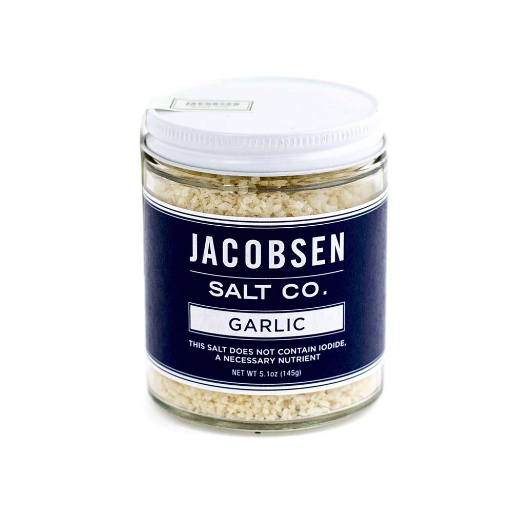 Glass jar with navy blue label. Filled with garlic salt.