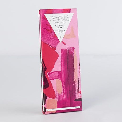 Chocolate bar in pink packaging with abstract brush strokes on it.