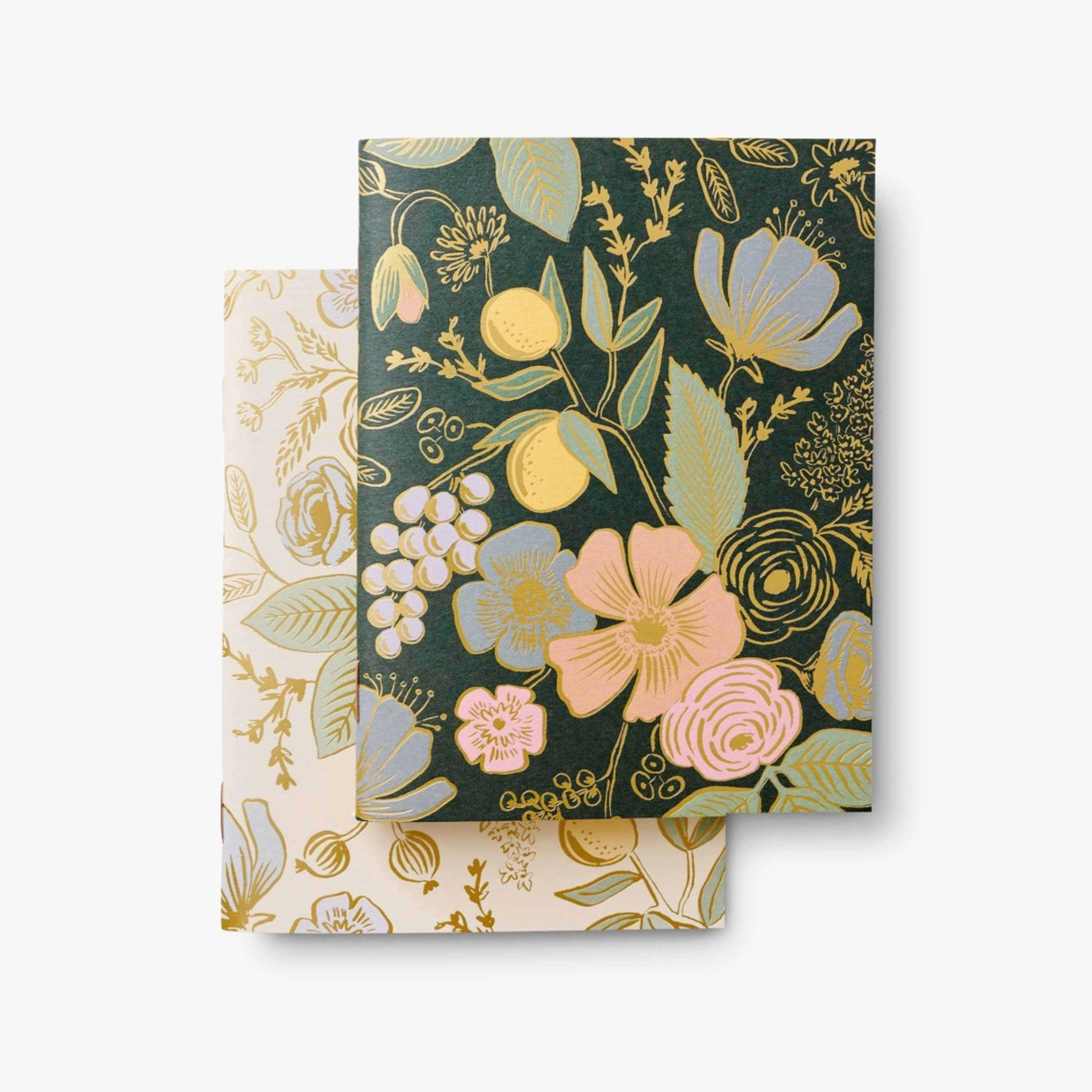 colette pocket notebooks (2) on a white surface. one dark toned notebook with flowers and one light toned notebook with flower pattern.