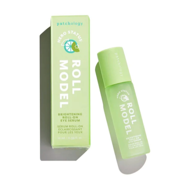 Light green rectangular box for Patchology Hero Status Roll Model Brightening Roll-On Eye Serum to the right of a light green cylindrical roller ball of Brightening Roll-On Eye Serum photographed on white background.