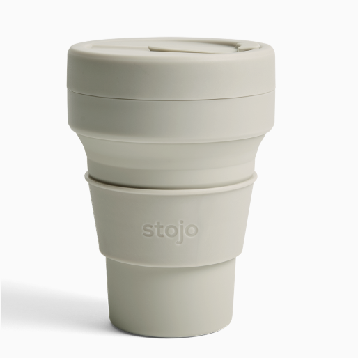 Plastic beige mug with silicone sleeve that reads, "stojo" photographed on white background. 