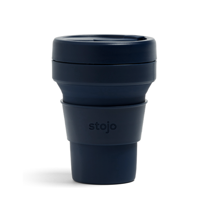 A navy plastic travel mug with silicone sleeve that reads, "stojo" photographed on white background.
