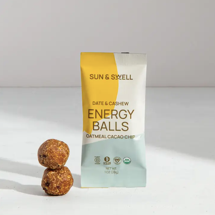 Oatmeal Cacao Chip energy ball packaging with two energy balls stacked to the left.