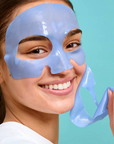 Girl peeling off face mask smiling
