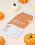 Pumpkin Spice Oat Milk Calming Plant-Based Milk Mask surrounded by mini pumpkins.