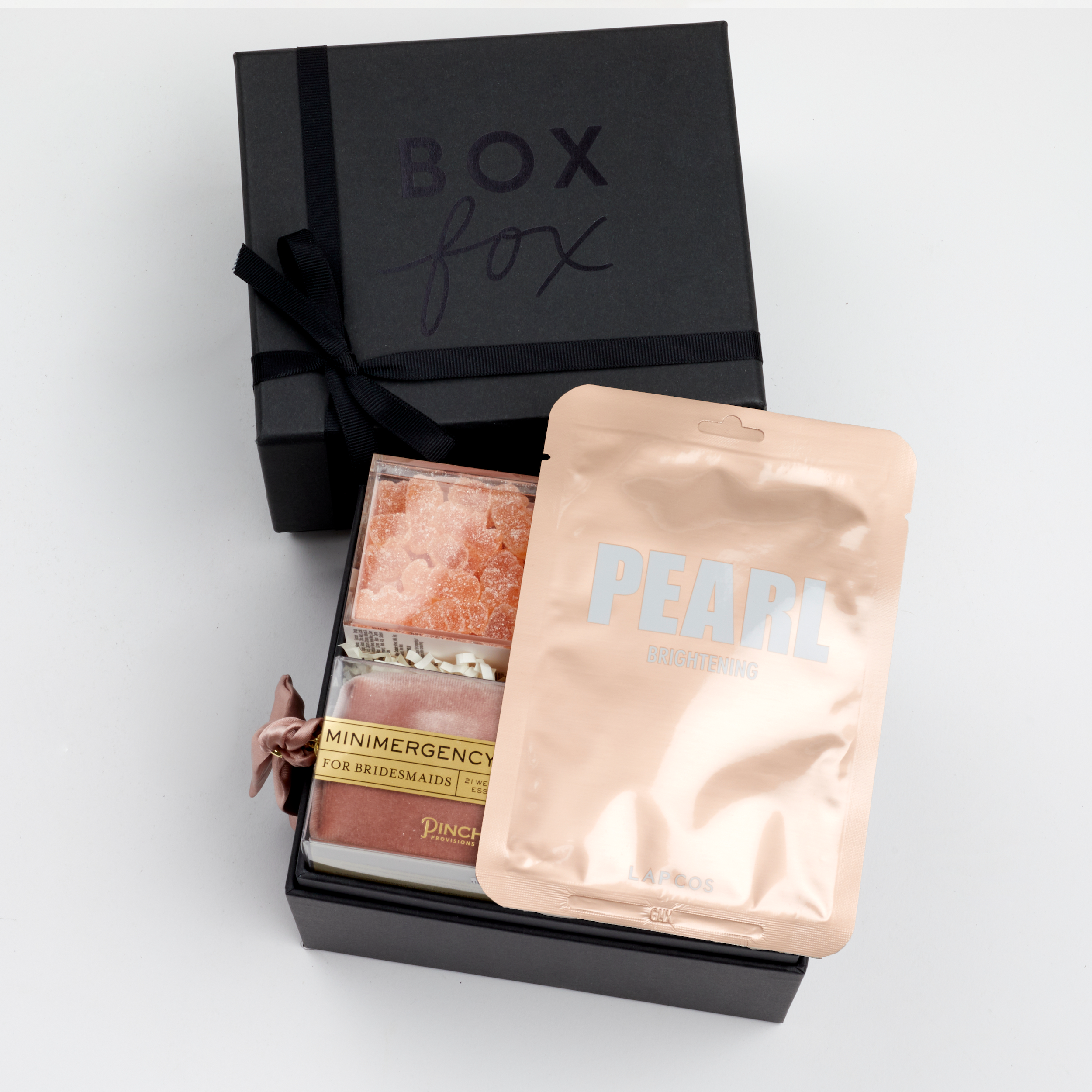 BOXFOX Bridesmaid Gift Box in Matte Black with Lapcos Pearl Brightening Mask, Sugarfina sparkling pink gummies, Pinch Provisions pinch velvet bridesmaids essential kit