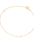 Dainty gold chain with small pearl in center.