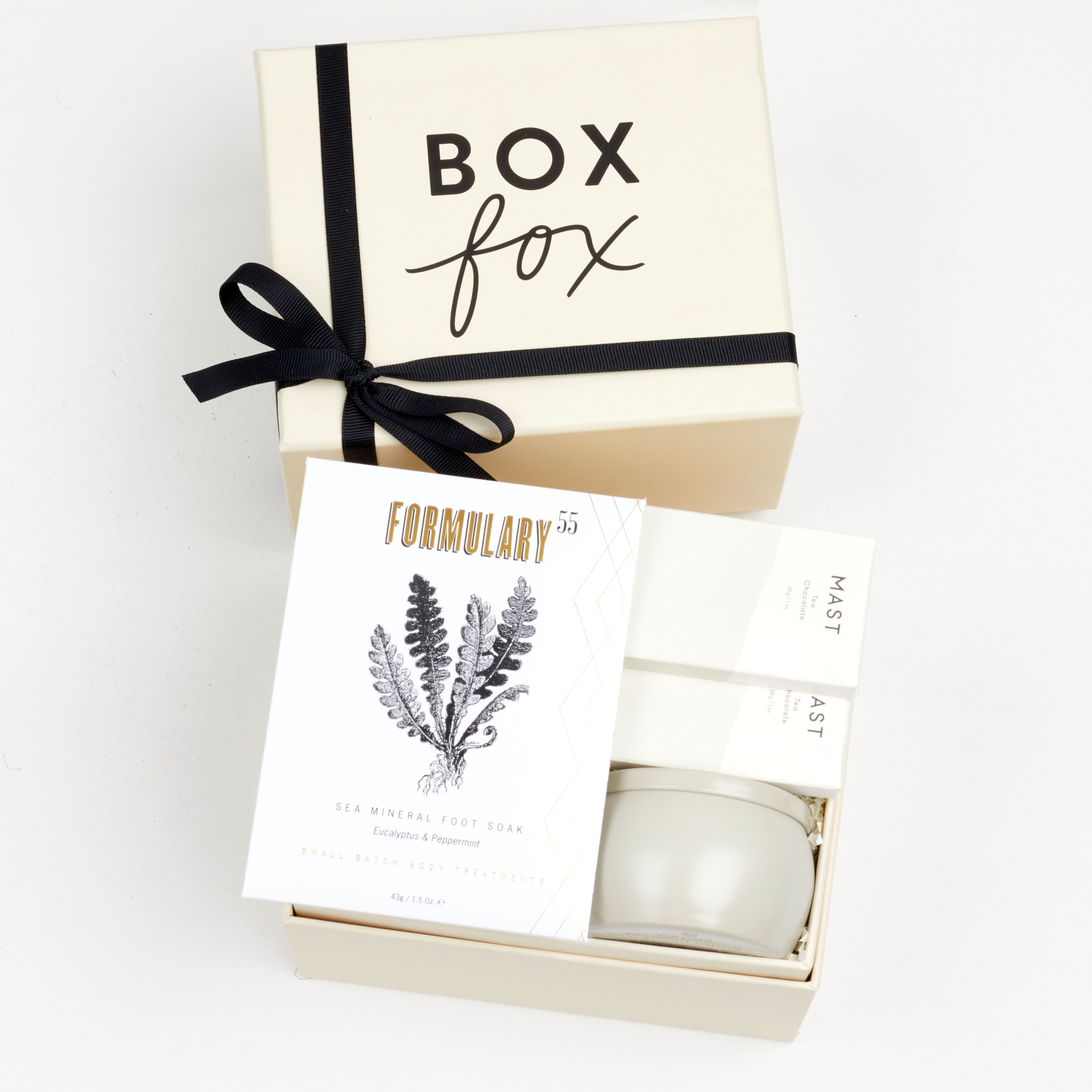 BOXFOX Creme Gift Box filled with Voluspa Coconut Papaya Tin Candle, Formulary 55 Eucalyptus + Peppermint Foot Soak and Mast Brothers 2 Mini Tea Chocolate Bars